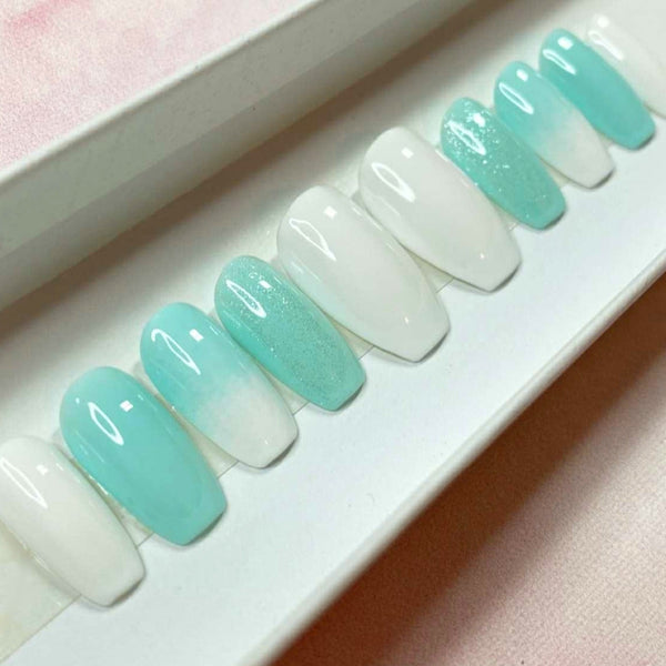 Load image into Gallery viewer, Short coffin pastel blue and white press-on nails with a white and blue ombre design and subtle glitter, in a white presentation box.