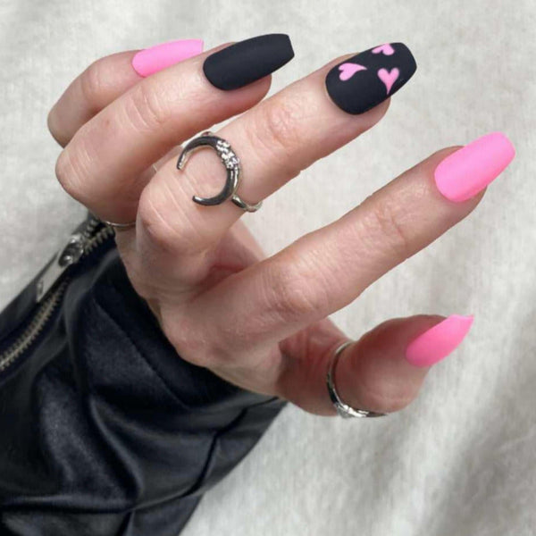 Load image into Gallery viewer, A photo of a hand with press-on nails featuring a pink and black matte design with pink hearts on the fingers.
