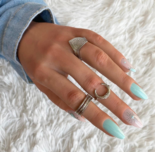 Load image into Gallery viewer, A hand wearing silver rings and handmade false nails in various shades of teal and natural colors, adorned with chrome designs such as hearts, moons, and stars.