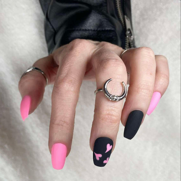Load image into Gallery viewer, Hand wearing pink and black press-on nails with a pink heart design on one finger, against a white background.
