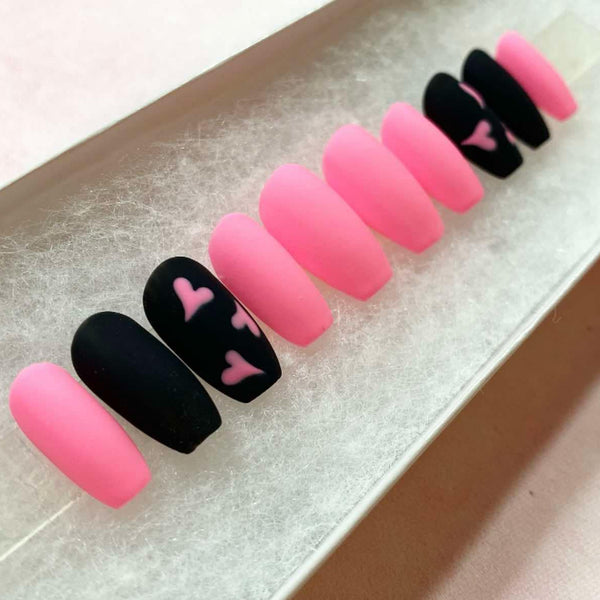 Load image into Gallery viewer, Short coffin press-on nails in bright pink and black, with a pink heart design on two nails, displayed in a white presentation box.