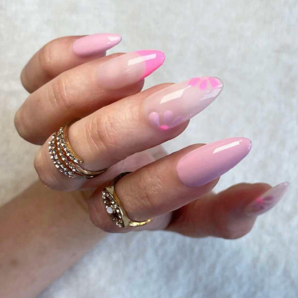 Load image into Gallery viewer, A hand wearing long almond press-on nails in varying shades of pink and lilac with floral accents and French tips, as well as gold rings.