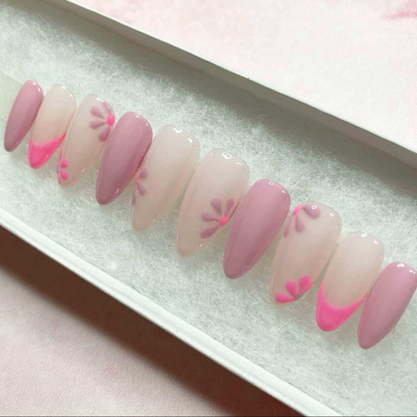 Load image into Gallery viewer, Press-on nails in varying shades of pink and lilac with floral accents and French tips, displayed in a white presentation box.