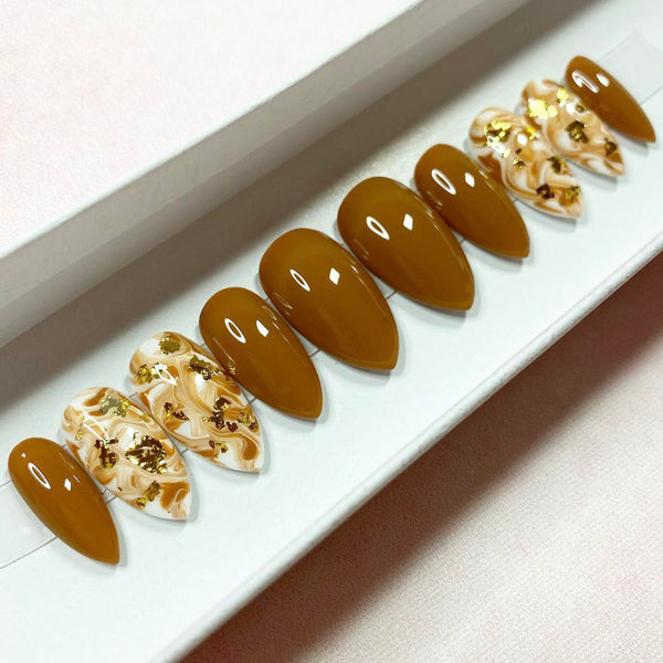 Load image into Gallery viewer, A set of short press-on nails in caramel and white with a marble design and gold foil accents.