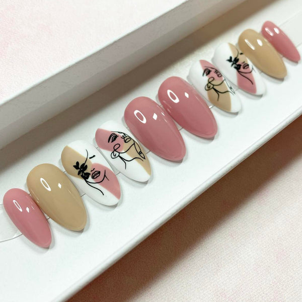 Load image into Gallery viewer, Press-on nails in beige and pink with abstract women's faces designs, from a UK-based nail artist