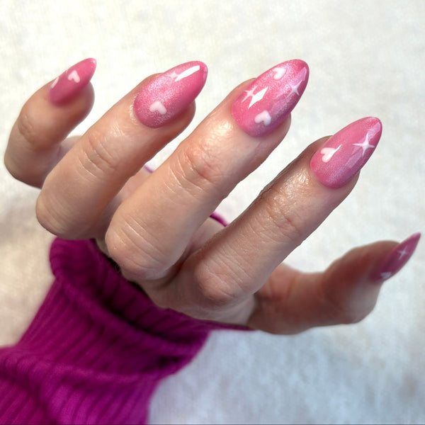 Load image into Gallery viewer, Hand wearing pink handmade acrylic nails featuring white heart and star designs, against a white background