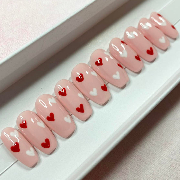 Load image into Gallery viewer, Short coffin pink handmade press-on nails with red and white heart designs, in a white presentation box.