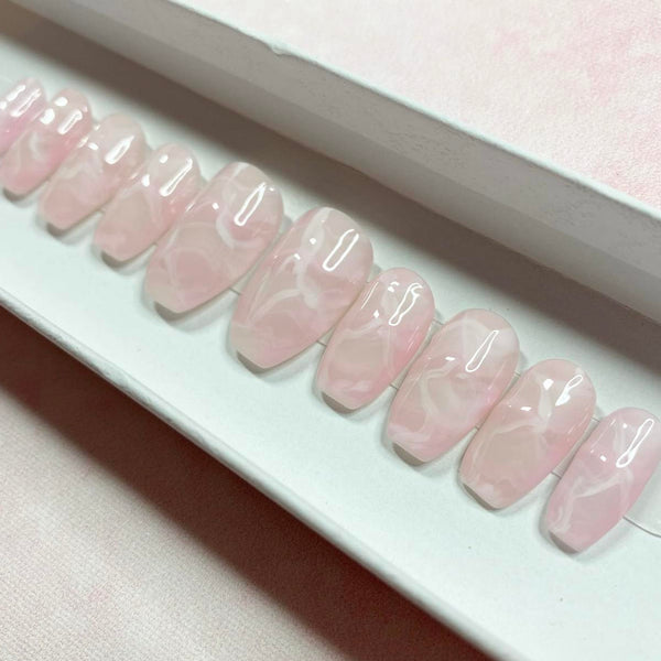 Load image into Gallery viewer, Short coffin press-on nails that resemble rose-quartz crystals, in a soft pink with a white marbling pattern, displayed in a white presentation box, created by Illuminate by Liana UK.