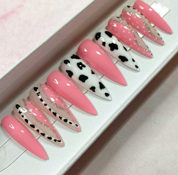 Load image into Gallery viewer, A set of long stiletto acrylic press-on nails with pink and cow print design, featuring silver glitter, displayed in a box.