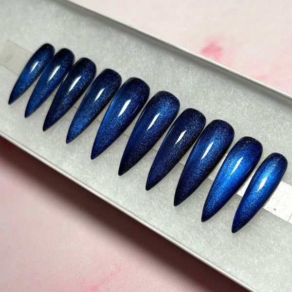Load image into Gallery viewer, Long stiletto blue cat eye press on nails displayed in a white presentation box, handmade by UK-based Illuminate by Liana
