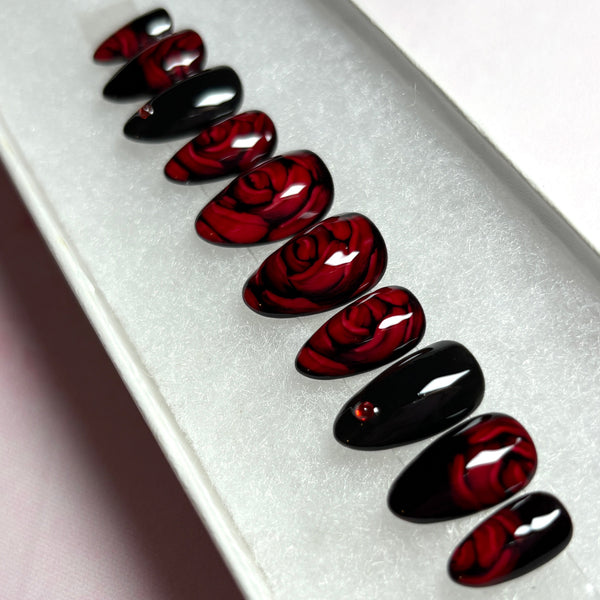 Load image into Gallery viewer, Short almond handmade floral press-on nails with 3D effect roses in dark red and black, adorned with delicate red rhinestones, in a short almond shape.