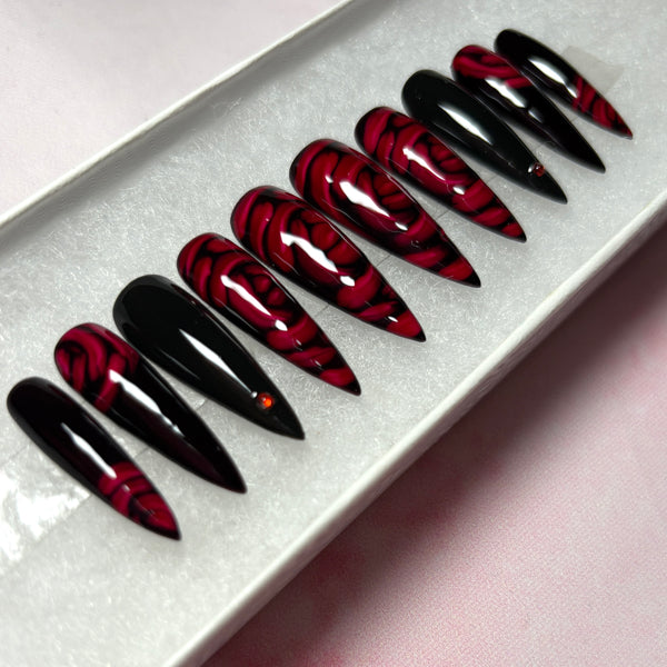 Load image into Gallery viewer, Red and black gothic style press-on nails featuring 3D effect deep red roses and delicate red rhinestones, in a long stiletto shape, displayed in a white presentation box.