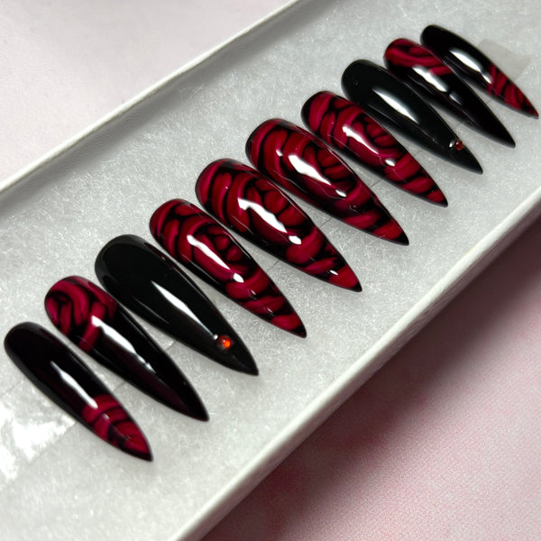 Load image into Gallery viewer, Red and black gothic style press-on nails featuring 3D effect deep red roses and delicate red rhinestones, in a long stiletto shape, displayed in a white presentation box.