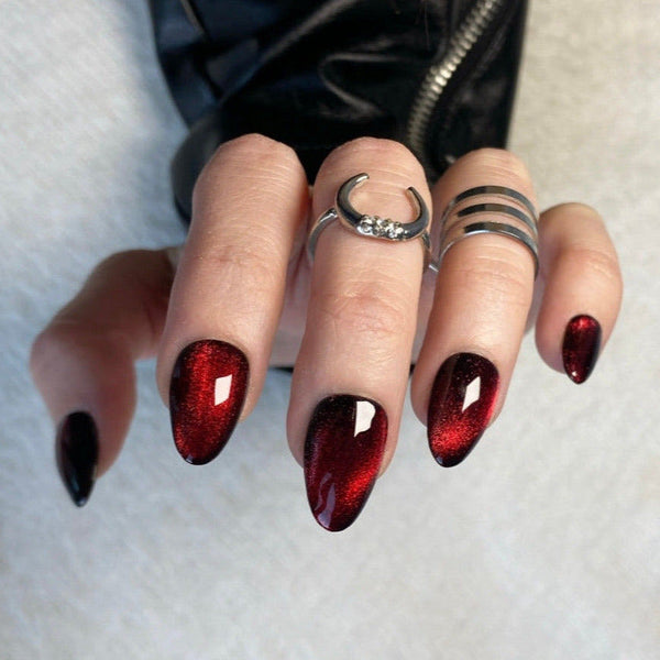 Load image into Gallery viewer, Close-up of a hand with handmade red and black press-on nails wearing two silver rings on a neutral background, from Illuminate by Liana