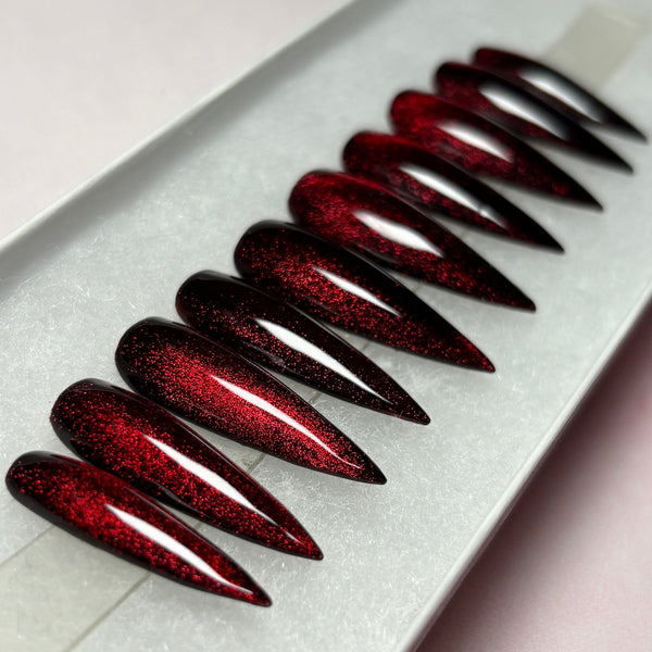 Load image into Gallery viewer, Red-black cat eye handmade press-on nails in a long stiletto shape, with shades that colour-change between red and black, in a white presentation box.