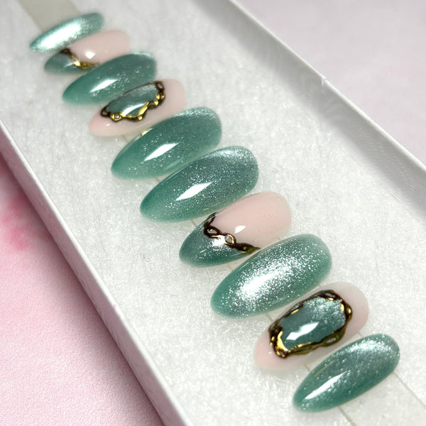 Load image into Gallery viewer, Press-on nails in shimmering green cat eye with delicate chain-design gold chrome accents, in a white presentation box.