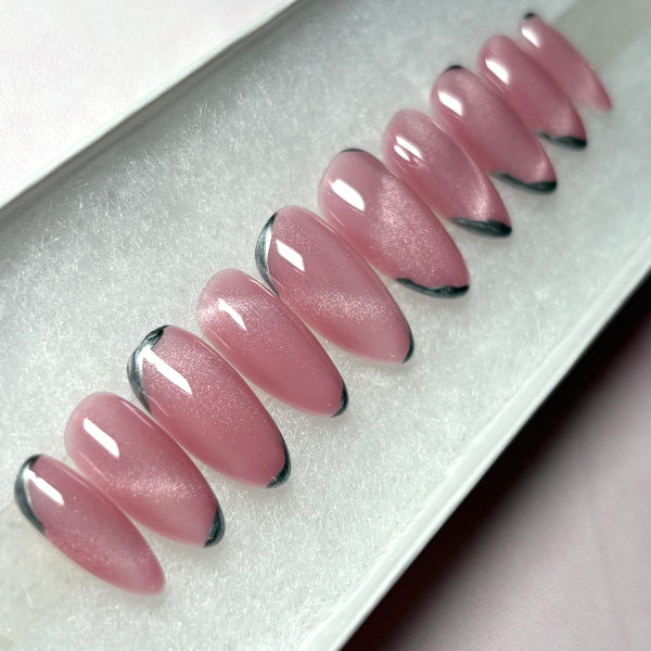 Load image into Gallery viewer, Almond shape pink press-on nails in shimmering cat eye, with silver chrome tips, in a white presentation box.