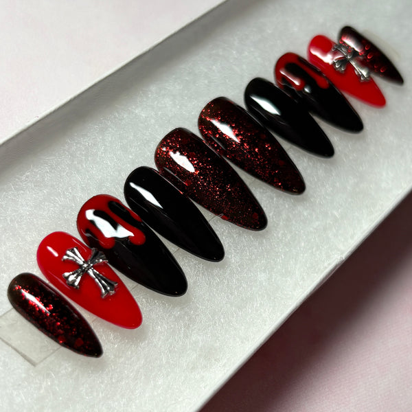 Load image into Gallery viewer, Gothic press-on nails in red and black featuring deep red blood drips, 3D silver cross gems, and deep red glitter, in a long almond shape, handmade by Illuminate by Liana Press-On Nails UK.