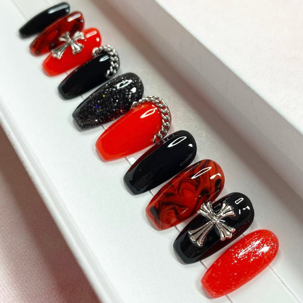 Load image into Gallery viewer, Short coffin gothic style press-on nails in red and black accented by silver cross gems, silver chains, a marble black-red pattern, and subtle glitter, in a white presentation box.