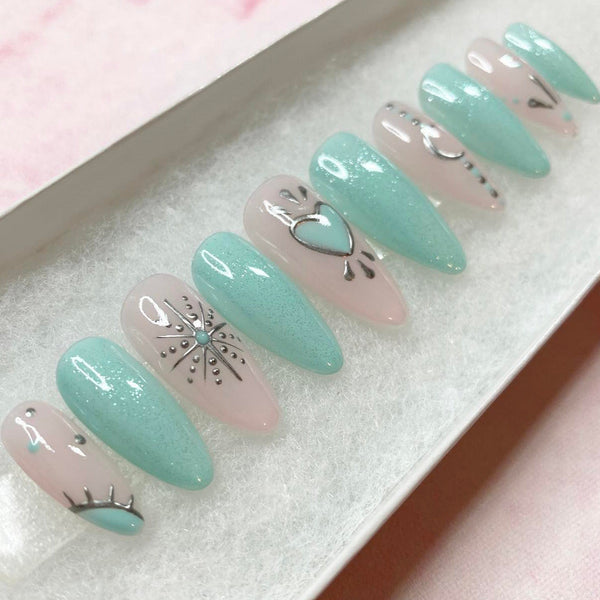Load image into Gallery viewer, Teal green and natural pink handmade press-on nails with silver chrome artwork depicting hearts, stars and crescent moons, in a long almond shape.