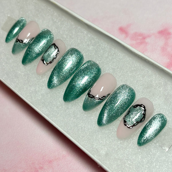 Load image into Gallery viewer, Handmade press-on nails in shimmery green cat eye with two green French tips and a delicate silver chrome 3D chain design accent, in a white presentation box.