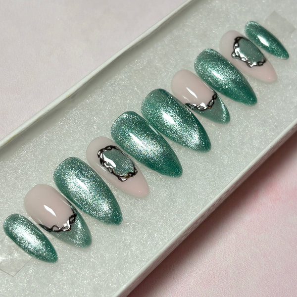 Load image into Gallery viewer, Long almond press-on nails in shimmery sage-green cat eye with two green French tips and a delicate silver chrome 3D chain design accent, from Illuminate by Liana