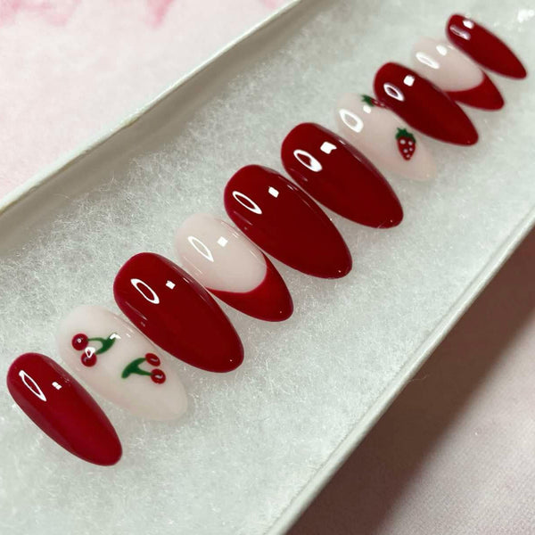 Load image into Gallery viewer, Short almond summery false nails featuring a deep burgundy red and soft pink colour, with a design of cherries and strawberries on some nails.