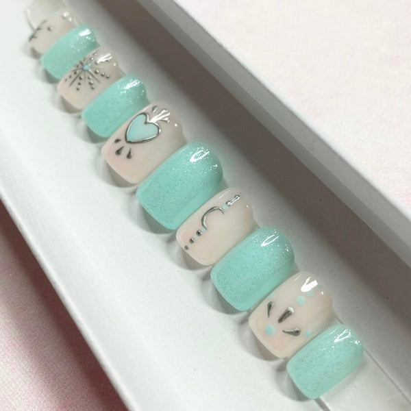 Load image into Gallery viewer, Short square handmade press-on nails in various shades of teal and natural colors, adorned with silver chrome designs such as hearts, moons, and stars.