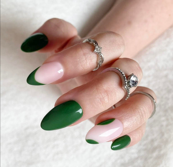 Load image into Gallery viewer, A close-up of a hand with long almond-shaped nails painted in a green and pale pink French manicure, wearing silver rings, against a soft white background.
