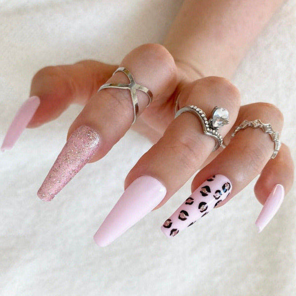 Load image into Gallery viewer, Hand wearing pink and leopard print press-on nails and silver rings on a light background