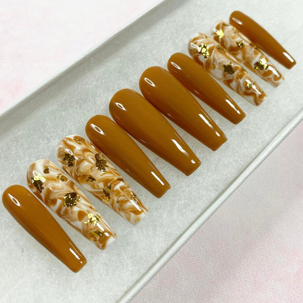 Load image into Gallery viewer, Long coffin caramel press-on nails in with a marble effect pattern and gold foil accents.