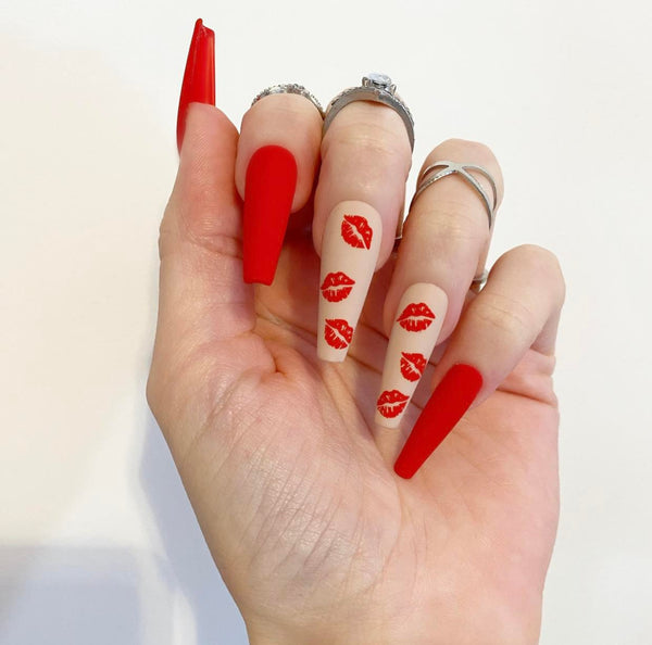 Load image into Gallery viewer, Hand showcasing handmade Valentine's press-on nails in red and nude with a matte finish and kiss mark designs