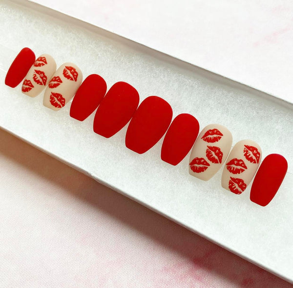 Load image into Gallery viewer, Valentine's handmade false nails in red and nude with a matte finish and kiss mark designs, in a short coffin shape