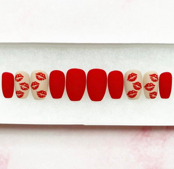 Load image into Gallery viewer, Valentine's handmade false nails in red and nude with a matte finish and kiss mark designs, in a short coffin shape