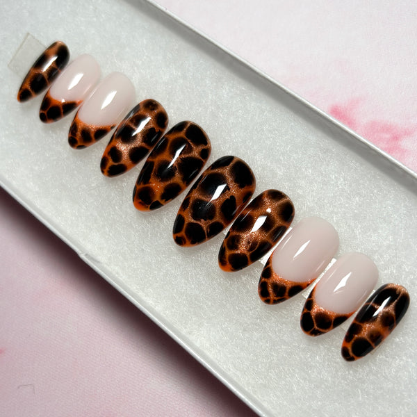 Load image into Gallery viewer, A set of handmade false nails featuring an animal print design that resembles leopard print or tortoiseshell in copper and deep brown-black, as well as four French tip nails tipped with the same animal print pattern, displayed in a white presentation box.
