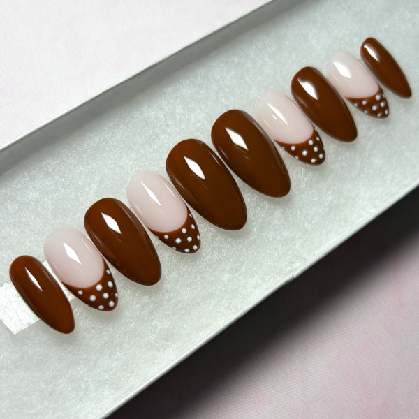 Load image into Gallery viewer, A set of press-on nails in deep chocolate-brown, featuring four brown French tip nails with white polka dots on the tips, and six glossy brown nails, handmade by Illuminate by Liana Press-On Nails UK.
