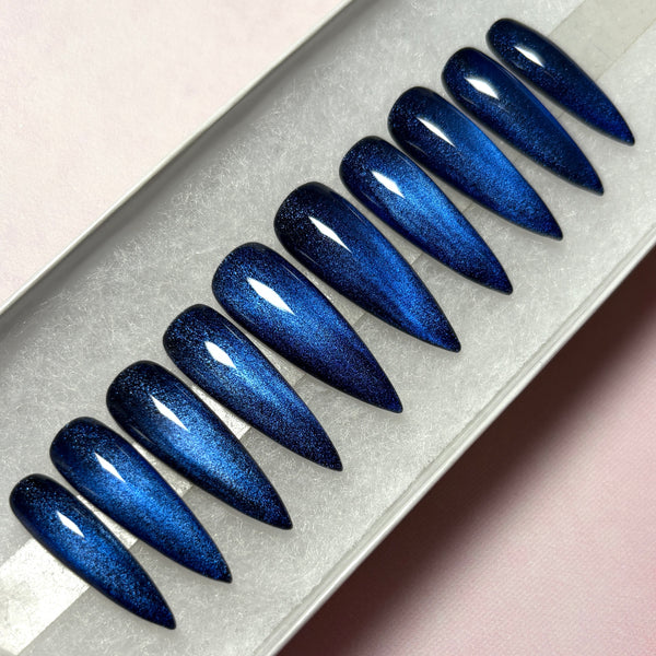 Load image into Gallery viewer, Cat eye handmade false nails in dark blue-black, in a long stiletto shape, displayed in a white presentation box, handmade in the UK by Illuminate by Liana
