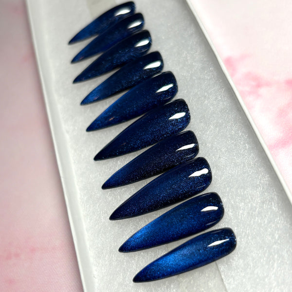 Load image into Gallery viewer, Long stiletto deep blue cat eye press on nails  displayed in a white presentation box. 
