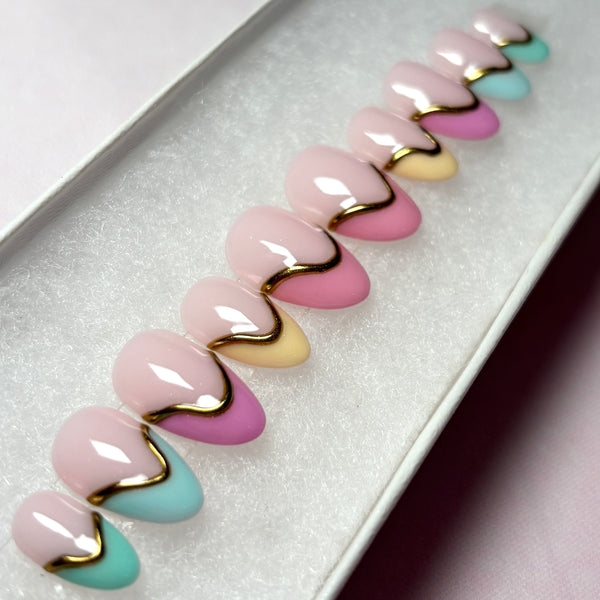 Load image into Gallery viewer, French tip press-on nails in a range of soft pastel shades with 3D gold chrome accents on each nail, in a short almond shape, handmade by Illuminate by Liana UK.
