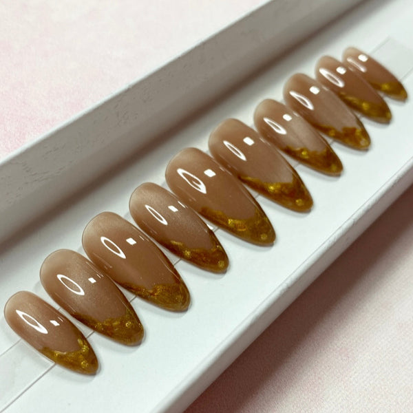 Load image into Gallery viewer, Long almond French tips false nails in shimmering pale brown cat eye and gold-copper French tips on each nail, in a white presentation box. 
