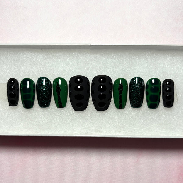 Load image into Gallery viewer, Handmade press-on nails in black and dark green, featuring a black snake design on a green background, snake print effect as 3D scales effect as well as subtle green glitter, displayed in a white presentation box.
