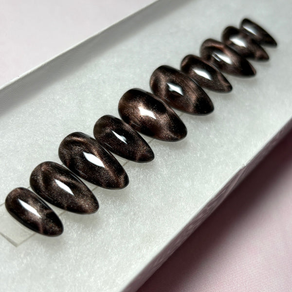 Load image into Gallery viewer, Autumn press-on nails in black featuring bronze brown cat eye that shimmers and glitters, giving a leopard print or tortoise shell effect, in a short almond shape handmade by Illuminate by Liana Press-On Nails UK.
