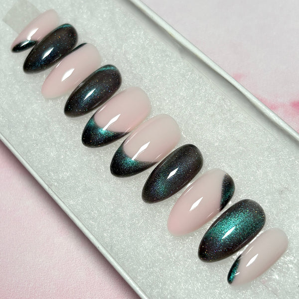 Load image into Gallery viewer, A set of cat eye press-on nails with shades of grey and green, on a soft pink base, in a short almond shape.
