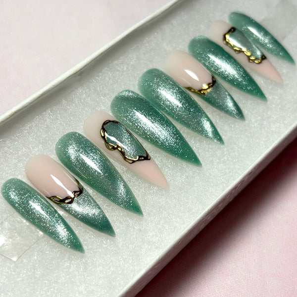 Load image into Gallery viewer, Jade green cat eye press-on nails with delicate gold chrome chain-like design accents, in a long stiletto shape. 
